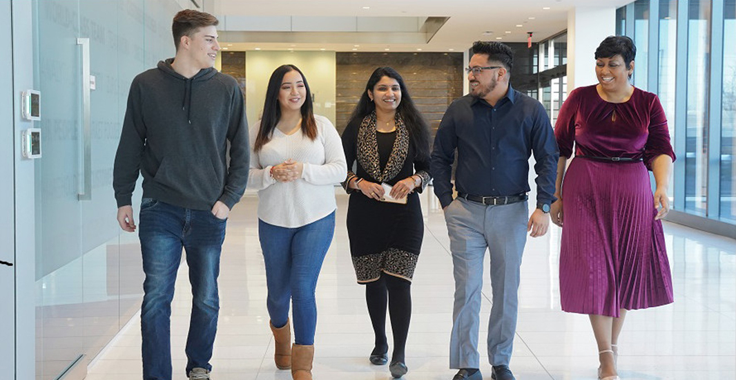 On the job: Zurich apprentices (from left): Jordan West, Liz Rodriguez, Sreelekha Sathiyamma, Jose Gonzalez and Trinette Patterson head to the coffee bar at Zurich North America’s headquarters in Schaumburg, Illinois, in February 2020. Sathiyamma graduated from the program in November 2020 and is now a Zurich cybersecurity analyst. Photo courtesy of Zurich North America.