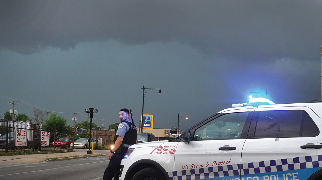 CHICAGO: A police officer stands guard following unrest on the city’s West Side moments before a derecho hits the area on Aug. 10, 2020. The storm, with wind gusts close to 100 mph, downed trees and power lines as it moved through the city and suburbs.